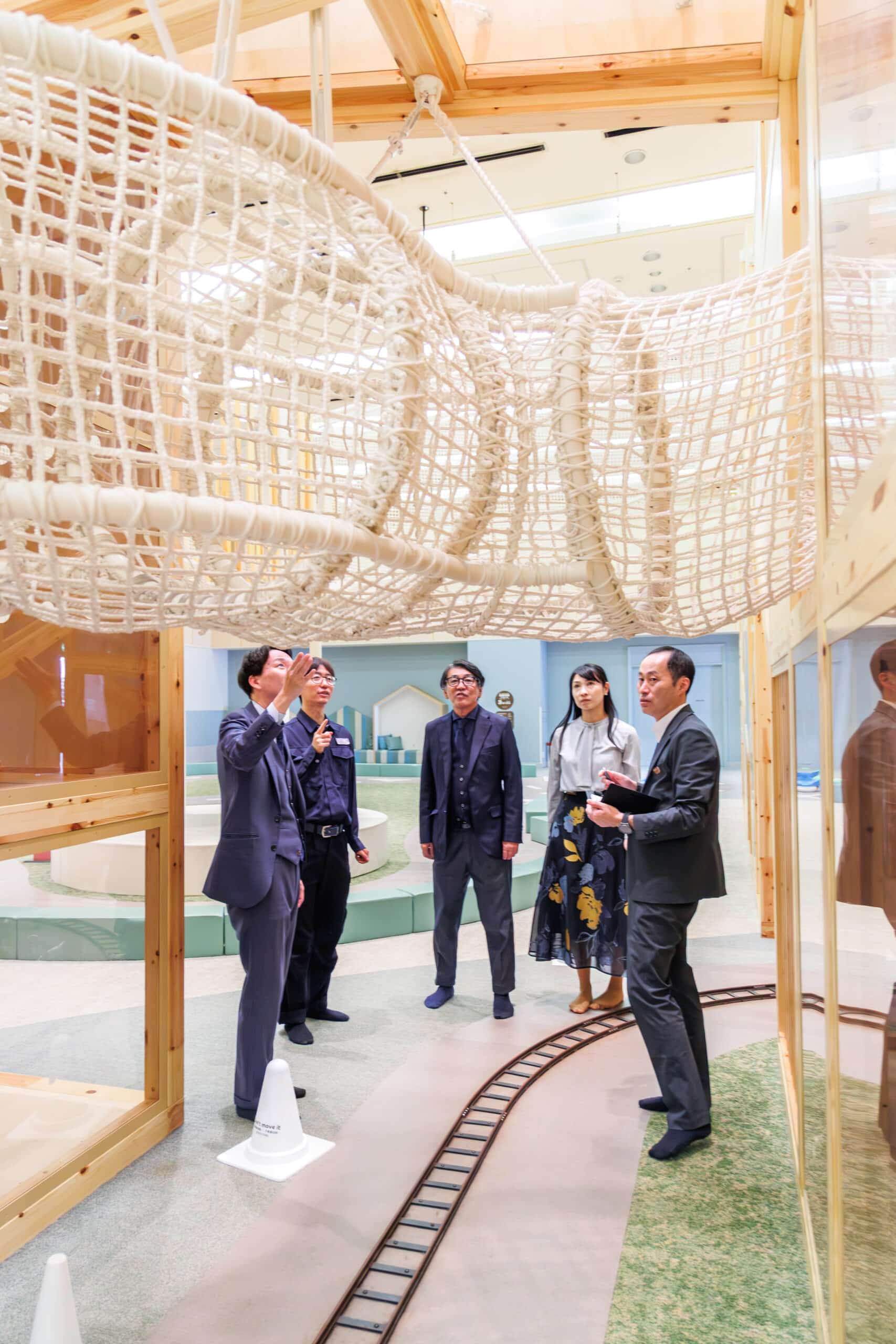 グランドメルキュール八ヶ岳リゾート＆スパの遊び場「杜のエイト」で関係者（大人）が遊具を見て話している様子